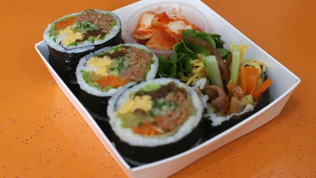 gimbap and kimchi in a small tray