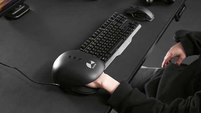The Hand Massager is placed next to a keyboard on a desktop. 