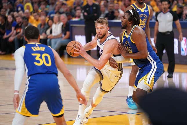 Apr 28, 2023; San Francisco, California, USA; Sacramento Kings forward Domantas Sabonis (10) holds onto the ball next to Golden State Warriors forward Kevon Looney (5) in the first quarter during game six of the 2023 NBA playoffs at the Chase Center.