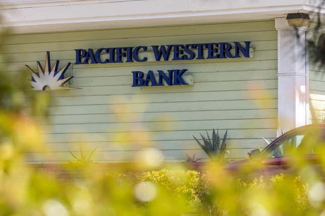 The pistachio-colored exterior of a Pacific Western Bank building, with the sign and logo in navy blue and white on the facade. 