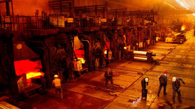 Workers clean the floors next to the hot rolling mill at the Sendzimir steel plant in Poland.