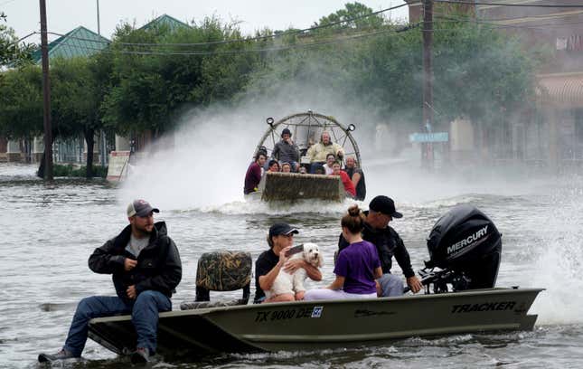 People and a pet are rescued from flood waters from Hurricane Harvey on an air boat in Dickinson, Texas Aug 27.