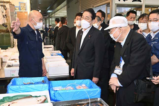 Japan&#39;s Prime Minister Fumio Kishida, center, speaks with a worker as he inspects Toyosu fish market in Tokyo Thursday, Aug. 31, 2023. Kishida visited the fish market to highlight fish safety and assess the impact of China&#39;s ban on Japanese seafood. (Kyodo News via AP)