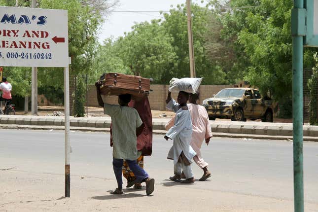 People flee with their belongings in Maiduguri a year ago.