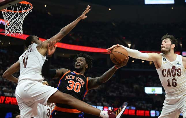 Apr 18, 2023; Cleveland, Ohio, USA; New York Knicks forward Julius Randle (30) drives to the basket between Cleveland Cavaliers forward Evan Mobley (4) and forward Cedi Osman (16) during the second quarter of game two of the 2023 NBA playoffs at Rocket Mortgage FieldHouse.