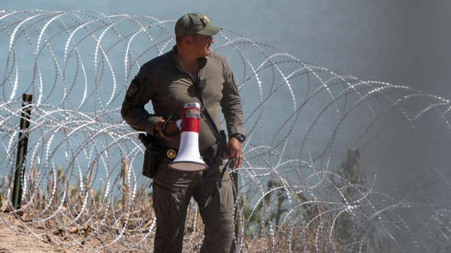 A Texas Department of Public Safety (DPS) highway patrol trooper looks over the Rio Grande at the US-Mexico Border on July 15, 2023 in Eagle Pass, Texas. The buoy installation is part of an operation Texas is pursuing to secure its borders, but activists and some legislators say Governor Greg Abbott is exceeding his authority. (Photo by SUZANNE CORDEIRO / AFP) (Photo by SUZANNE CORDEIRO/AFP via Getty Images)