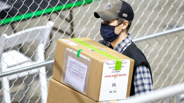 A contractor for Cyber Ninjas transporting ballots from Maricopa County's 2020 general election at Veterans Memorial Coliseum in Phoenix, Arizona, in May 2021.