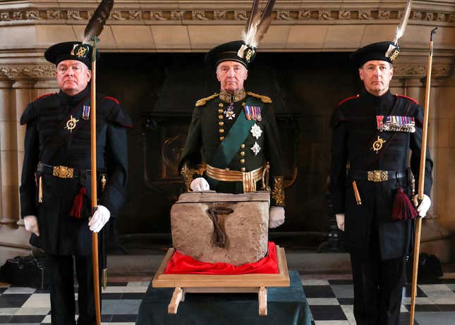 The Duke of Buccleuch (C) flanked by two members of The Royal Company of Archers stand by the Stone of Destiny in Edinburgh Castle