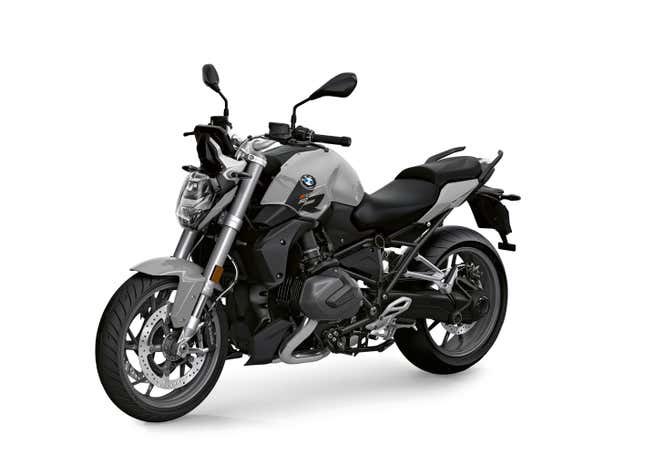 A gray and black BMW motorcycle is parked in front of a white background.