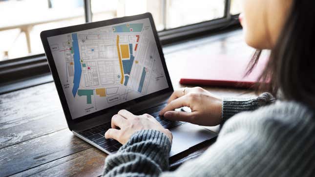 Woman looks at map on laptop