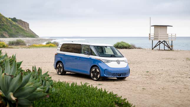 A two-tone blue and white 2025 VW ID Buzz electric van is parked on the beach.
