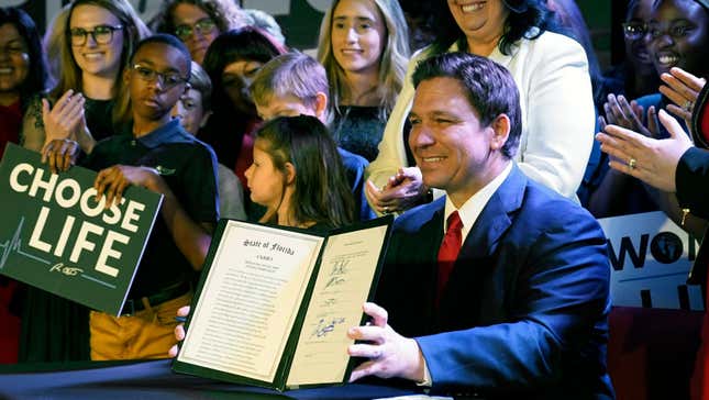 Florida Gov. Ron DeSantis holds up a 15-week abortion ban law after signing it, Thursday, April 14, 2022, in Kissimmee, Fla.