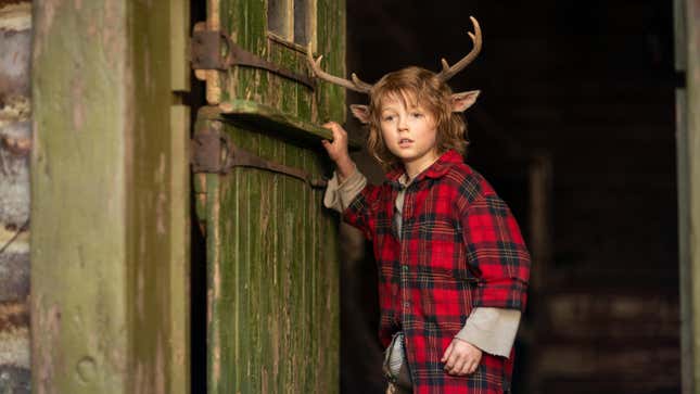 Deer child Gus (Christian Convery) peers out a barn door in Netflix's Sweet Tooth.