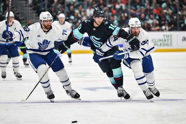 Feb 26, 2023; Seattle, Washington, USA; Toronto Maple Leafs defenseman TJ Brodie (78) and Seattle Kraken center Matty Beniers (10) and Toronto Maple Leafs center Auston Matthews (34) chase the puck during the second period at Climate Pledge Arena.