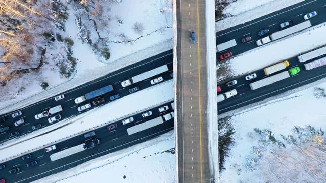 Snow covers the Interstate 95 as trucks and cars remain stuck.