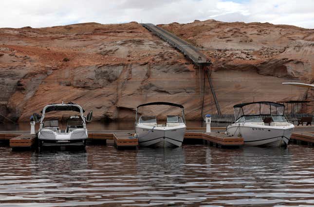 Boats sit docked near a ramp that falls short of the water at Lake Powell,
