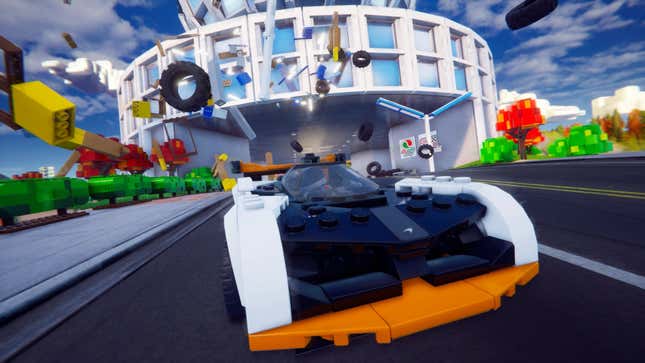 A Lego car is seen crashing through another Lego car with its broken parts in the background.