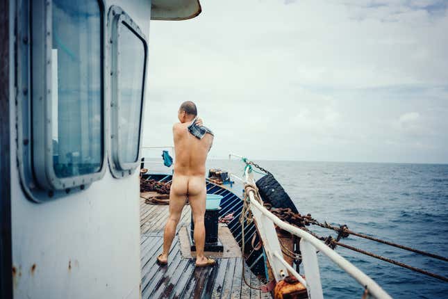 A Chinese engineer bathes on the deck of a fishing vessel off the coast of Guinea-Bissau.