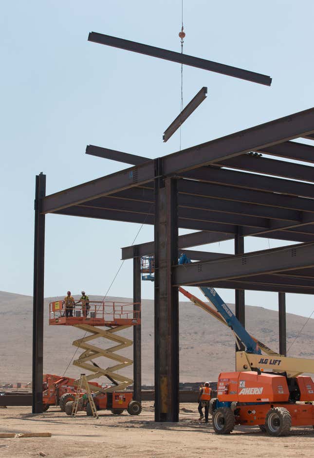 Support beams are lowered in to position during the construction of the new Tesla Motors Inc., Gigafactory, Tuesday, July 26, 2016, in Sparks, Nev. It's Tesla Motors biggest bet yet: a massive, $5 billion factory in the Nevada desert that could almost double the world's production of lithium-ion batteries by 2018. (AP Photo/Rich Pedroncelli)