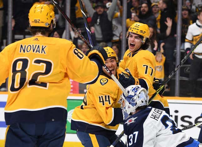Mar 18, 2023; Nashville, Tennessee, USA; Nashville Predators right wing Luke Evangelista (77) celebrates with left wing Kiefer Sherwood (44) and center Tommy Novak (82) after a goal against Winnipeg Jets goaltender Connor Hellebuyck (37) during the third period at Bridgestone Arena.