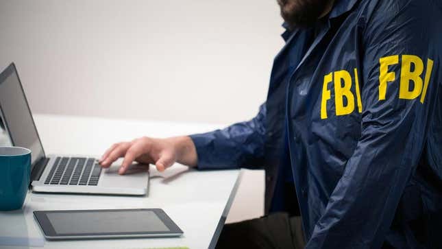 An FBI officer using a laptop.
