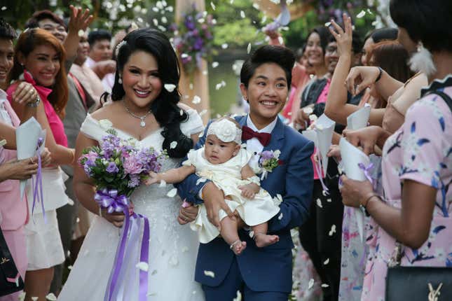 Bride Amornrat Ruamsin, 27, who is a transgender, holds up her five-month-old daughter with her groom Pitchaya Kachainrum, 16, during their wedding ceremony in Bangkok. The ceremony was not legally-binding, since Pitchaya is under 17, the legal age for marriage in Thailand. The couple plan to officially wed after her birthday.