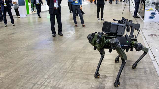 A photo of a Ghost Robotics dog with a gun strapped to its back.