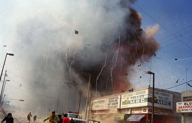 Rescue workers and residents flee as a fourth explosion sounds at a market area in downtown Celaya, Mexico, Sunday, Sept. 26, 1999. At least 56 people were killed when a series of explosions erupted, sparked by a supply of gunpowder used for making fireworks.