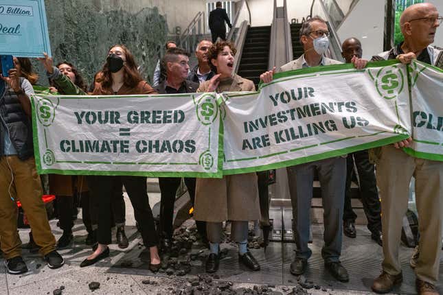 Climate activists block an escalator and throw coal on the ground at the New York headquarters of the financial investment firm BlackRock in October. 