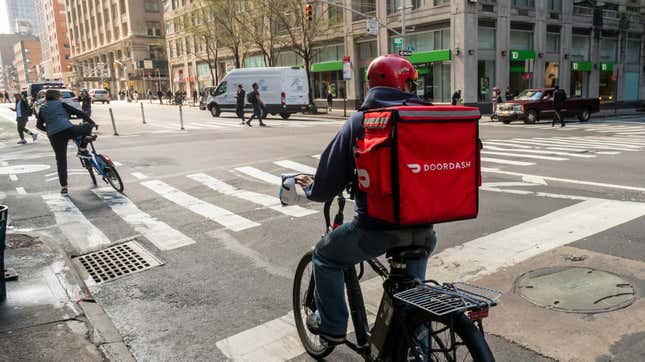 A delivery person with a DoorDash branded tote on his bicycle in the Chelsea neighborhood of New York