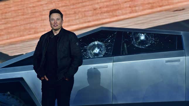 Tesla co-founder and CEO Elon Musk stands in front of the shattered windows of the newly unveiled all-electric battery-powered Tesla’s Cybertruck