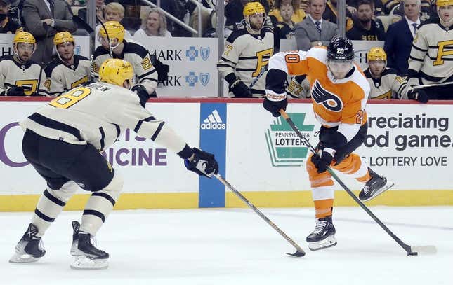 Mar 11, 2023; Pittsburgh, Pennsylvania, USA;  Philadelphia Flyers left wing Kieffer Bellows (20) shoots as Pittsburgh Penguins defenseman Brian Dumoulin (8) defends during the first period at PPG Paints Arena.  Pittsburgh won 5-1.