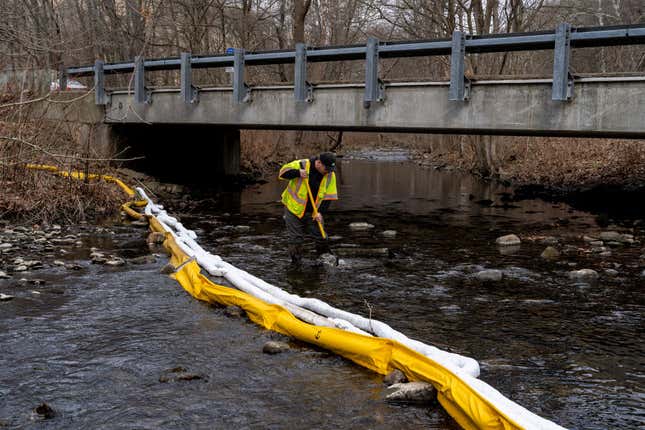 Ron Fodo, Ohio EPA Emergency Response, looks for signs of fish and agitates the water in Leslie Run creek to check for chemicals that have settled at the bottom. 