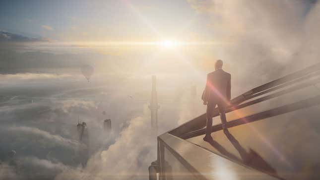 Agent 47 stands on top of a tower in Dubai and looks at a cloudy landscape in Hitman 3.