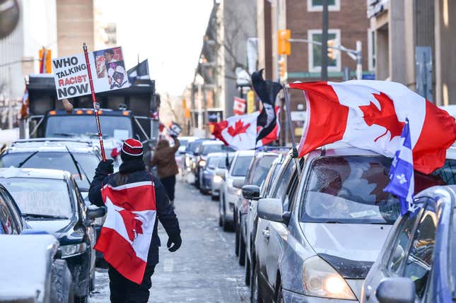 A protester of the vaccine mandates introduced by Canadian Prime Minister Justin Trudeau, walks down Metcalfe Street draped in a Canadian flag on February 5, 2022 in Ottawa, Canada.