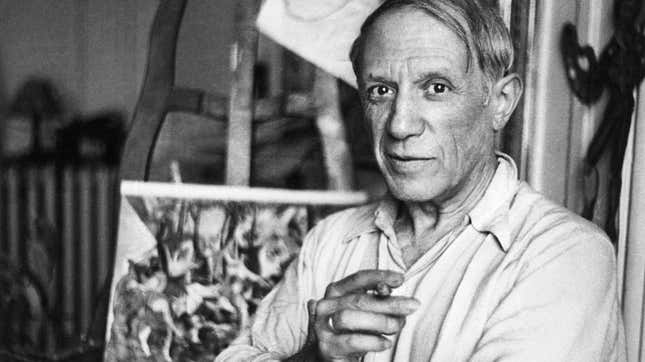 Pablo Picasso smoking a cigarette in his Paris studio