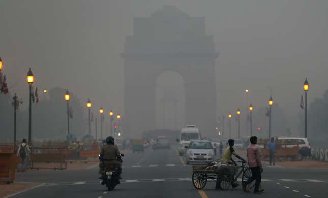 Traffic moves in front of the landmark India Gate monument enveloped by a blanket of smog, caused by a mixture of pollution and fog, in New Delhi, India, Tuesday, Nov. 6, 2012. Environmentalists say that the level of pollution in the city has reached an alarming level, according to news reports.