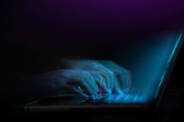 A set of hands typing on a computer shaded in blue.
