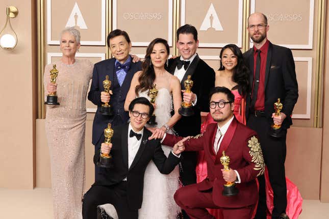 The cast of Everything Everywhere All at Once poses on the red carpet with their Oscar statues.