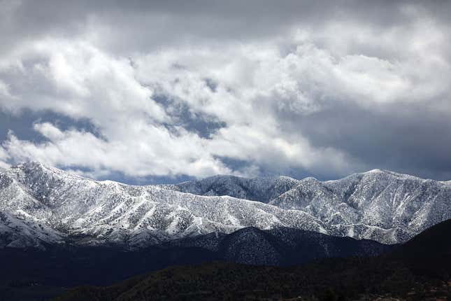 Storm clouds pass over snow-covered mountains in Los Angeles County during another winter storm in Southern California on March 01, 2023 near Acton, California. 