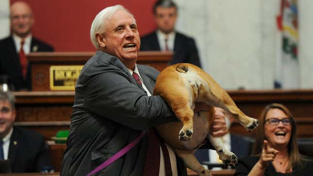 West Virginia Gov. Jim Justice holds up his dog Babydog's rear end as a message to people who've doubted the state as he comes to the end of his State of the State speech in the House chambers, Thursday, Jan. 27, 2022, in Charleston, W.Va. 