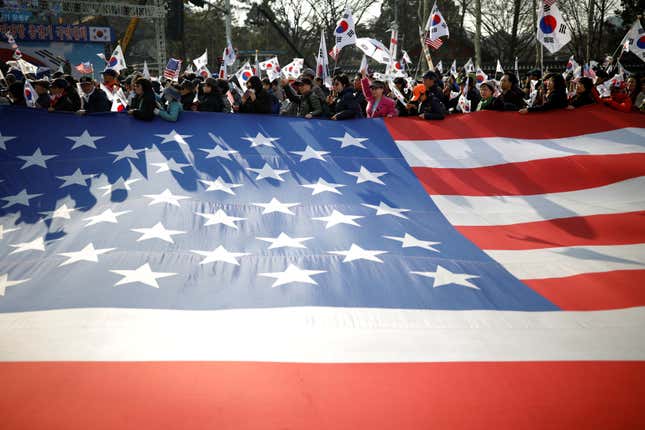 Supporters of South Korea’s ousted leader Park Geun-hye hold a giant US flag as they march during a protest in Seoul, South Korea, March 11, 2017.