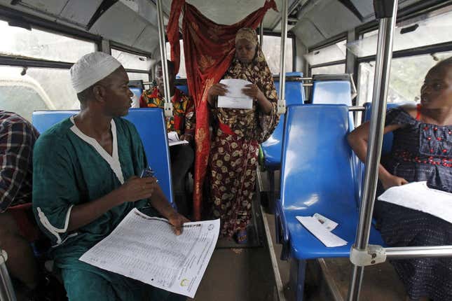 A woman prepares to cast her vote in an old bus which is used as a polling station during a presidential election in Conakry, Guinea.