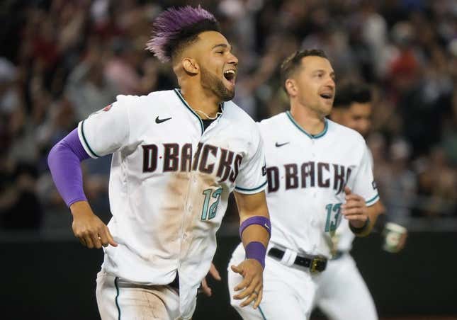 May 6, 2023; Phoenix, AZ, USA; Arizona Diamondbacks    Lourdes Gurriel Jr. (12) and Nick Ahmed (13) run out on to the field to celebrate their 8-7 win over the Washington Nationals at Chase Field.