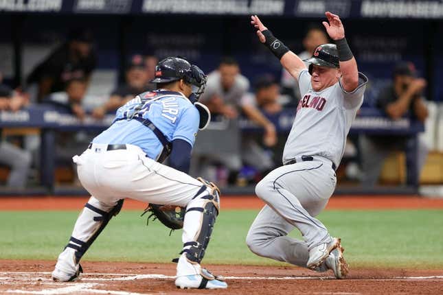 Aug 13, 2023; St. Petersburg, Florida, USA;  Cleveland Guardians first baseman Kole Calhoun (56) scores a run past Tampa Bay Rays catcher Christian Bethancourt (14) in the third inning at Tropicana Field.