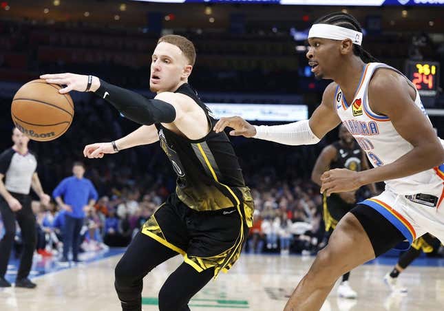 Mar 7, 2023; Oklahoma City, Oklahoma, USA; Golden State Warriors guard Donte DiVincenzo (0) reaches for a loose ball in front of Oklahoma City Thunder guard Shai Gilgeous-Alexander (2) during the second quarter at Paycom Center.