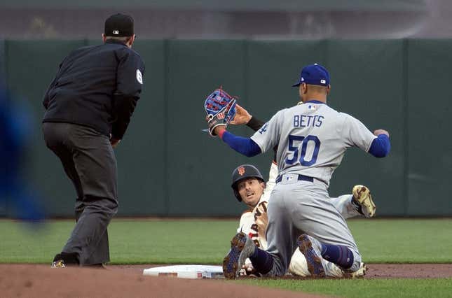 Apr 10, 2023; San Francisco, California, USA; Los Angeles Dodgers second baseman Mookie Betts (50) tags out San Francisco Giants right fielder Mike Yastrzemski (5) as he is caught attempting to steal second base during the first inning at Oracle Park. Umpire is Alex Tosi.