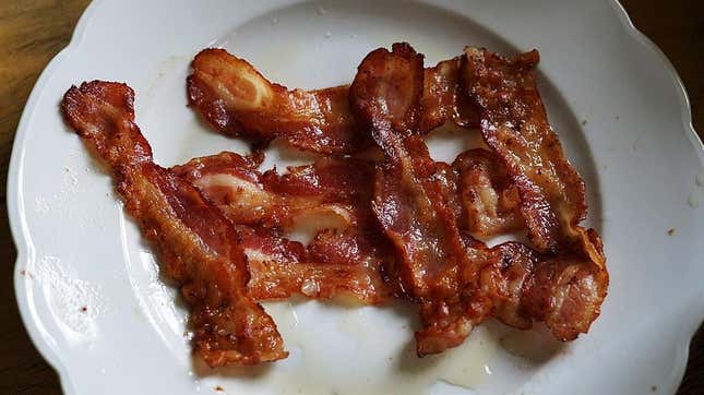 Strips of cooked bacon on white plate