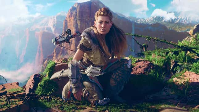 Aloy crouches on a mountain summit in a cinematic trailer screenshot