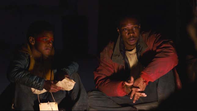 Sam and Henry (Keivonn Woodard and Lamar Johnson) sit during a meal scene in HBO's The Last of Us.